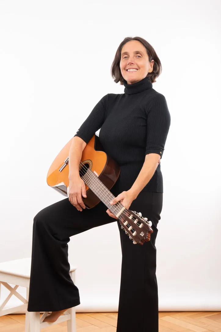 Ina Haferkorn mit Gitarre, einen Fuß auf einem Hocker